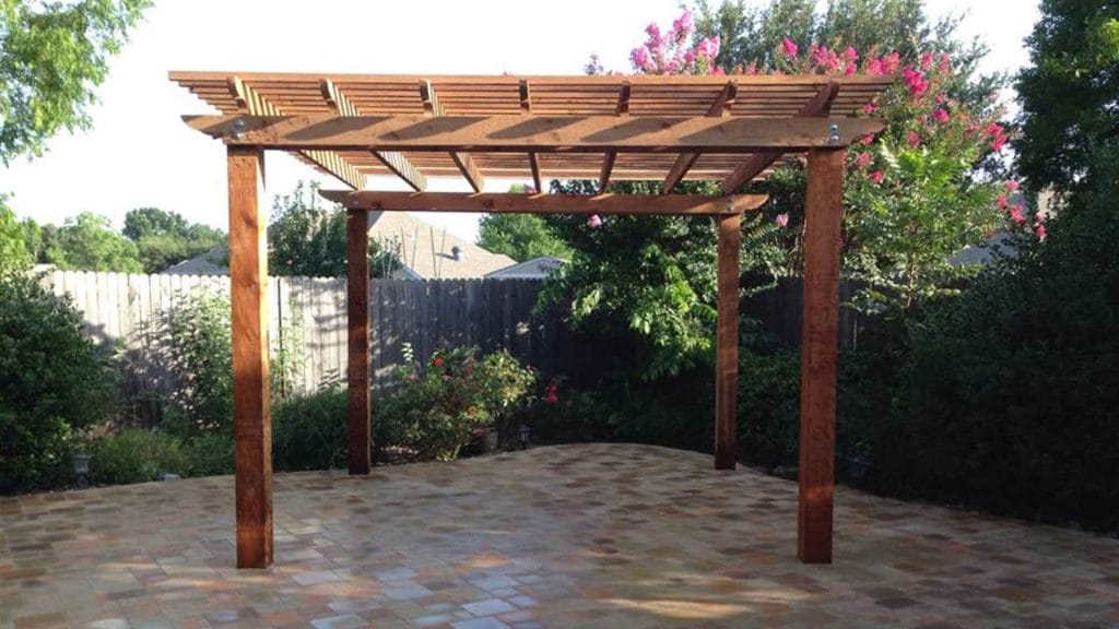 Freestanding wood pergola above a patterned patio